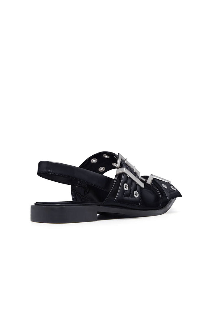 Side view of black patent flats with multiple silver buckles, eyelets, and a slingback strap