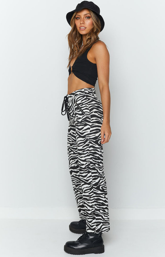 Black and white zebra print high waisted pants with a black drawstring lace-up front and side zipper pockets